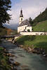 913143_Bergdorf Ramsau Kirche St. Sebastian Bild über Ache Wasserfluß Holzbrücke unter Wolken über Alpen Berchtesgadenerland