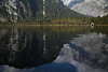 Knigssee felsiger Naturufer Foto mit Holzhtte am Wasserufer unter Bergwand